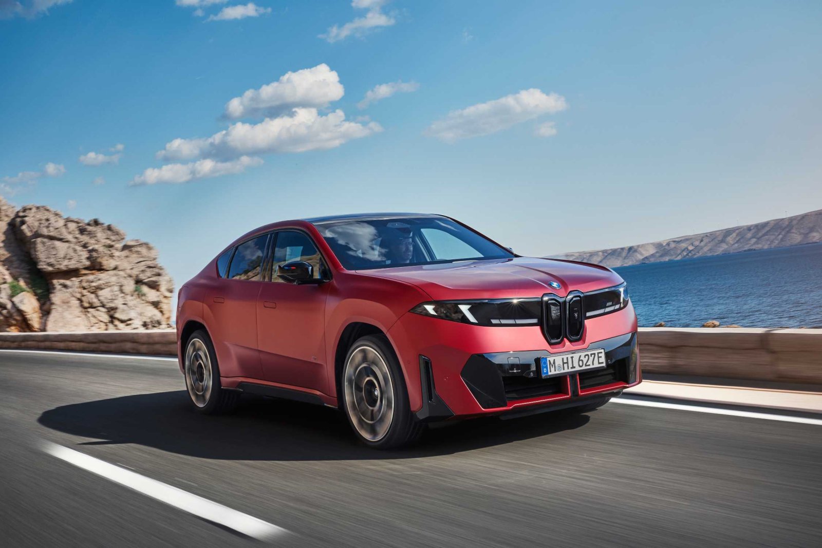 Kırmızı BMW iX4 deniz kenarında önden