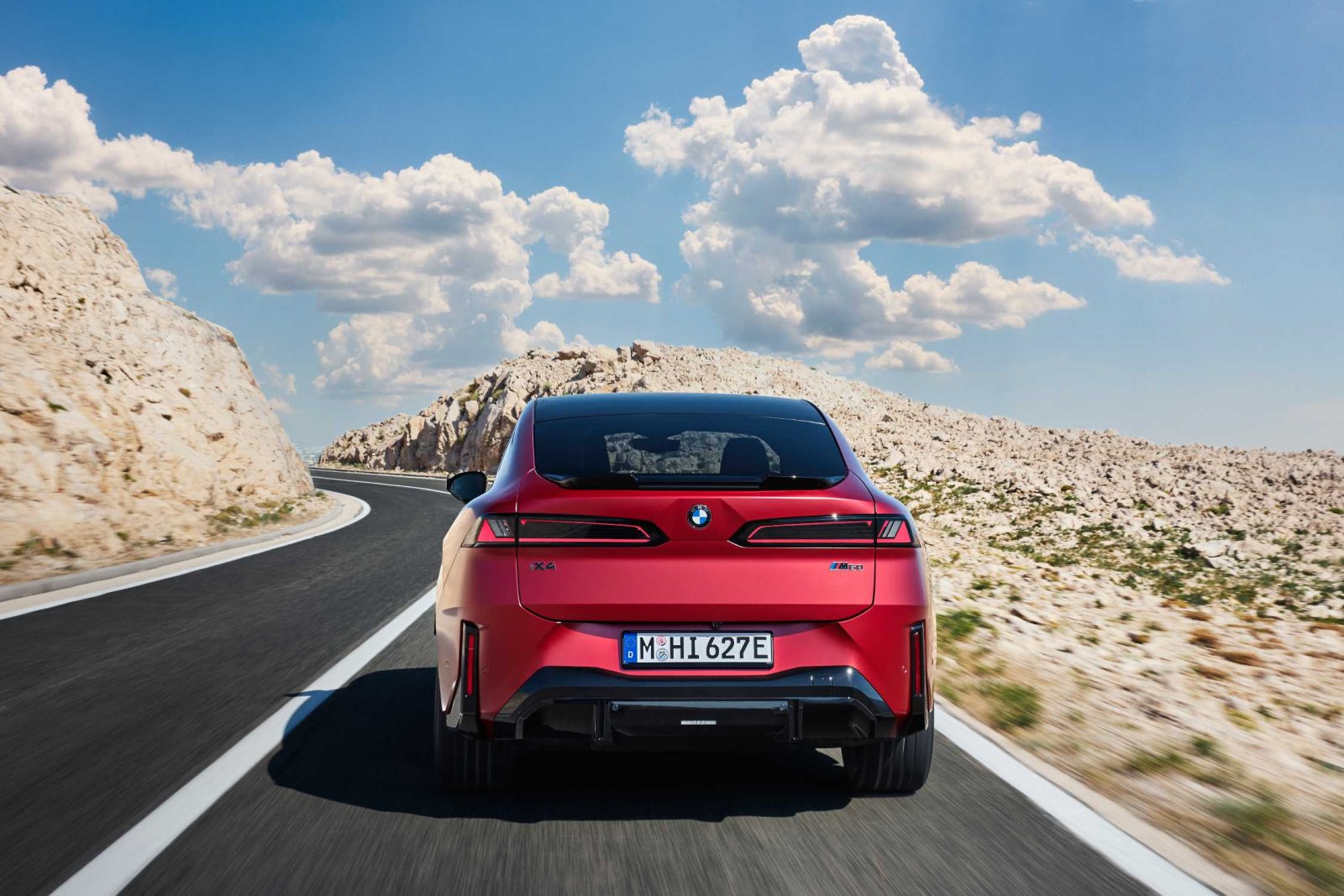 Kırmızı BMW iX4 tam arkadan görünüm