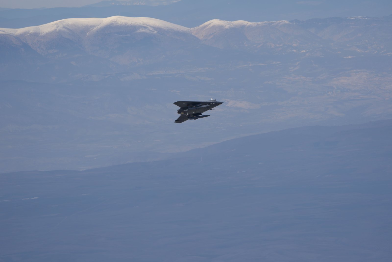 ANKA-3 insansız savaş uçağı, karlı dağların üzerinde uçuş halinde.